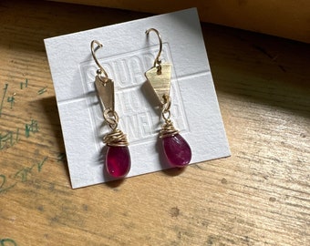 The "Josie" earring, handcut and refined 14k GF triangle shape, a red ruby teardrop shaped  bead and a 14k GF metal hook