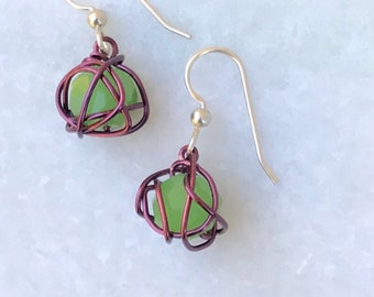 Leesa earring: bright green glass bead with purple colored wire and sterling silver earwire