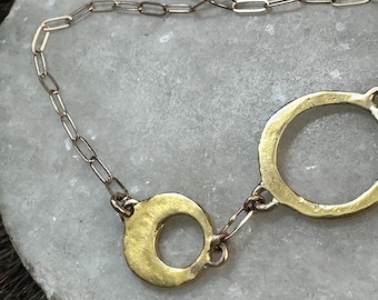 Alicia link necklace with five different sized circles with different characteristics, wide framed circles solid circle and cut out circle