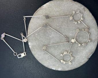 Penny necklace: A sculpted open and closed circle pendulum style chain necklace