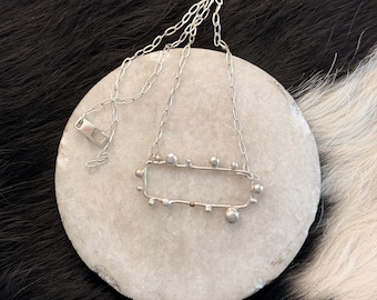 Sculpted bubble and ball accented rectangle necklace on 18 inch paperclip chain