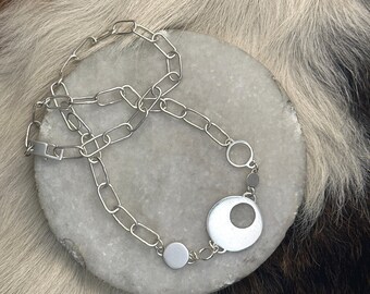 Alicia link necklace with four different sized circles with different characteristics, wire framed circles solid circle and cut out circle
