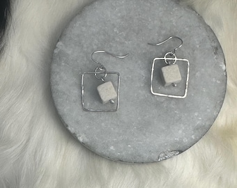 Uma earring a silver square frame with hammered texture and a square riverstone bead hanging inside