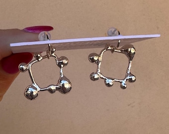 sculpted silver square with solid silver balls adoring the outside of circle