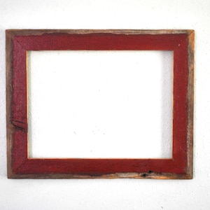 May include: A rustic wooden picture frame with a red painted border. The frame is made of reclaimed wood and has a natural, weathered look.