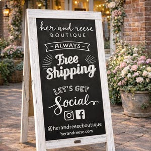 May include: A-frame chalkboard sign with white frame. The sign reads "her and reese BOUTIQUE - ALWAYS - Free Shipping. LET'S GET Social" with social media handles. The sign is on a brick patio.