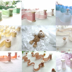 May include: Assortment of ten spools of silk ribbon in various colours, including light blue, light pink, light green, beige, and ivory. The ribbon is arranged in a decorative fashion on a white surface.