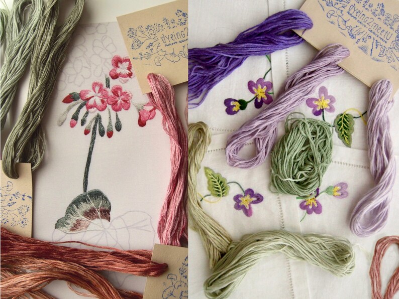 May include: Assortment of embroidery floss in various shades of green, pink, purple, and brown. The floss is arranged on a white fabric background with embroidered flowers and leaves.