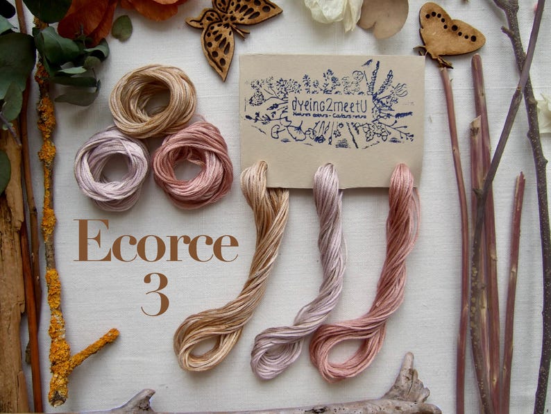 Trois échevettes de fil de coton à broder 6 brins moulinés de 8 mètres chacune, dans des tons gradués de beige, beige gris, beige rose.
Les fils sont présentés sur une carte avec la marque "Dyeing2meetU". Ils sont teints à la main en France. Pour commander il faut sélectionner "3 - Ecorce"