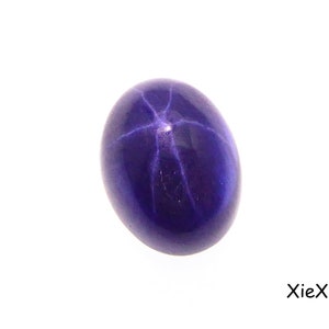 Könnte beinhalten: Ein tiefvioletter Stern-Saphir mit einem sechszackigen Sternmuster.