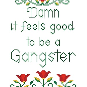 以下が含まれることがあります： 緑色の「Damn it feels good to be a Gangster」という文字が入ったクロスステッチのデザイン。赤、緑、黄色の花柄と葉柄のデザイン。背景は白です。