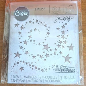 May include: A package of Sizzix Thinlits dies featuring a star design. The package includes the Sizzix logo, the text "Jim Holtz ALTERATIONS", and the text "9 DIES | 9 MATRICES | 9 TROQUELES | 9 FUSTELLE | 9-ВЫРУБКИ | 9 STANZEN | 9 CORTANTES".