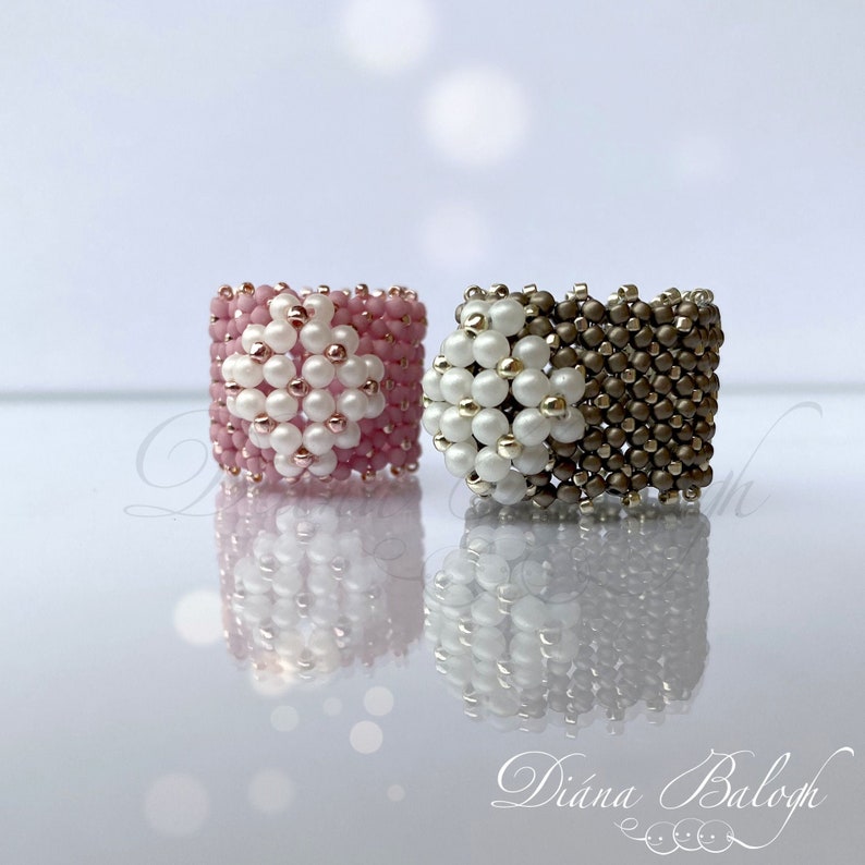 May include: Two beaded rings, one pink and one brown, with white beads forming a flower design.