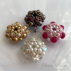 Pode incluir: Quatro pingentes de flores com contas em diferentes cores e designs. Os pingentes são feitos com contas pequenas em cores dourado, branco, rosa e vermelho. Os pingentes têm um laço na parte superior para prender a um colar ou pulseira.