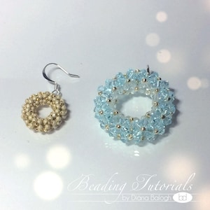 Puede incluir: Un par de pendientes, uno con cuentas de color azul claro y el otro con cuentas doradas. Ambos pendientes tienen forma de círculo.
