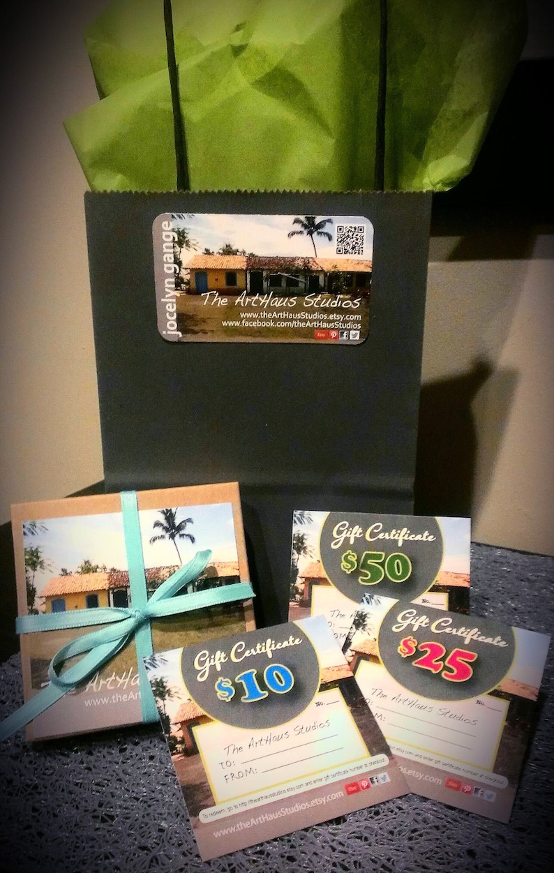 May include: Four gift certificates for The ArtHaus Studios, with values of $10, $25, $50, and $100. The certificates feature a tropical scene with a blue sky, palm trees, and a yellow building.