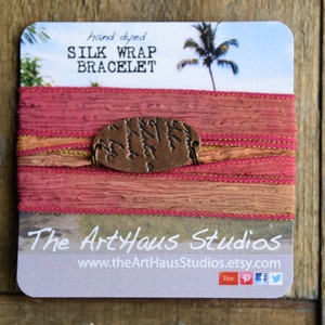 Puede incluir: Pulsera de envoltura de seda teñida a mano con un dije de cobre con diseño de árbol. La pulsera se muestra en una tarjeta con el texto "hand dyed SILK WRAP BRACELET" y "The ArtHaus Studios www.theArtHausStudios.etsy.com".