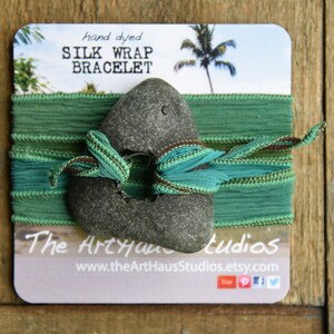 May include: Hand-dyed silk wrap bracelet in teal and brown with a gray stone accent. The Art Haus Studios logo and website are printed on the card.