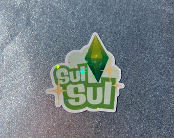 May include: A green and white sticker with the text "sul sul" and a green diamond shape. The sticker has a glittery finish.