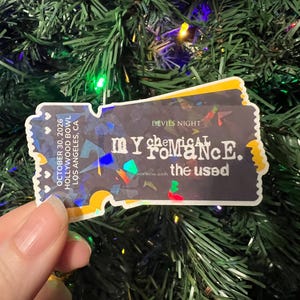 May include: A sticker resembling a concert ticket, featuring the text "My Chemical Romance" and "the used." The ticket design includes the date "October 30, 2026" and "Hollywood Bowl, Los Angeles, CA." The background is a festive green.