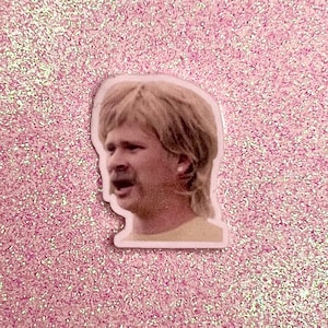Könnte beinhalten: Nahaufnahme eines Mannes mit einem überraschten Gesichtsausdruck. Er hat blondes Haar und einen Schnurrbart. Er trägt ein weißes Hemd.