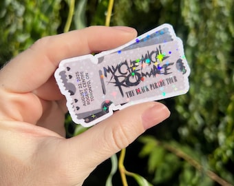 Op de afbeelding: Een holografische sticker in de vorm van een concertkaartje. Het kaartje toont de tekst "MY CHEMICAL ROMANCE" in een gestileerd lettertype, samen met "THE BLACK PARADE TOUR". De datum "AUGUST 22, 2025" en de locatie "ROGERS CENTRE TORONTO, ON" staan ook op het kaartje.
