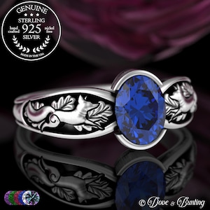 May include: A sterling silver ring with an oval, deep blue gemstone. The ring has a fox and leaf design on the band. The image text reads "GENUINE STERLING 925 SILVER hand crafted nickel free MADE IN THE USA".