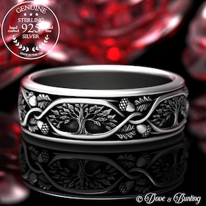 Puede incluir: Un anillo de plata de ley con un diseño de árbol de la vida. El anillo está hecho a mano y es libre de níquel. El anillo representa un árbol con hojas y bellotas, y las palabras "GENUINE STERLING 925 SILVER" están grabadas en la banda. El anillo está hecho en los Estados Unidos.