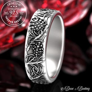 May include: A sterling silver ring with a detailed floral design. The ring features an intricate pattern of pinecones and foliage, hand-crafted from 925 silver. The ring is nickel-free and made in the USA.
