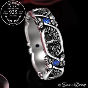 May include: A silver ring with a tree of life design and two blue gemstones. The ring is made of sterling silver and is nickel free. The ring is made in the USA.