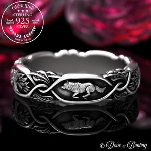 May include: A silver ring with a wolf motif. The ring showcases a detailed wolf image within an oval frame, framed by an intricate, interwoven design. The ring is marked "925 Silver" and "Made in the USA".