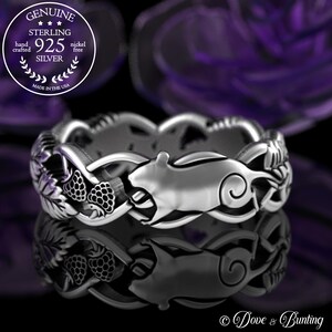 May include: Sterling silver ring featuring a detailed design of a stylized animal with a curled tail, surrounded by leaves and berries. The ring is made in the USA and is nickel free.