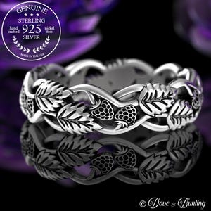 May include: A silver ring featuring a design of leaves and berries. The ring is made of sterling silver and is nickel-free. The image includes the text "GENUINE STERLING 925 SILVER hand crafted nickel free MADE IN THE USA".