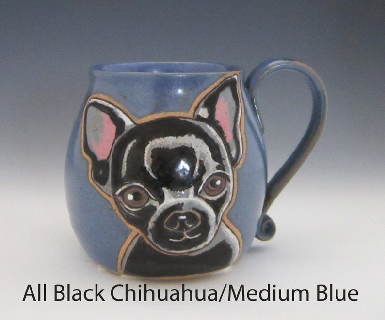 Puede incluir: Una taza de cer&aacute;mica con un esmalte azul y una imagen pintada a mano de un chihuahua negro. El chihuahua tiene orejas rosas y una nariz negra.