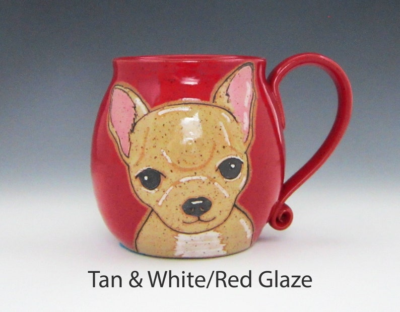 Puede incluir: Una taza de cer&aacute;mica roja con una ilustraci&oacute;n de chihuahua marr&oacute;n y blanco. La taza tiene un cuerpo redondeado y un asa curva.