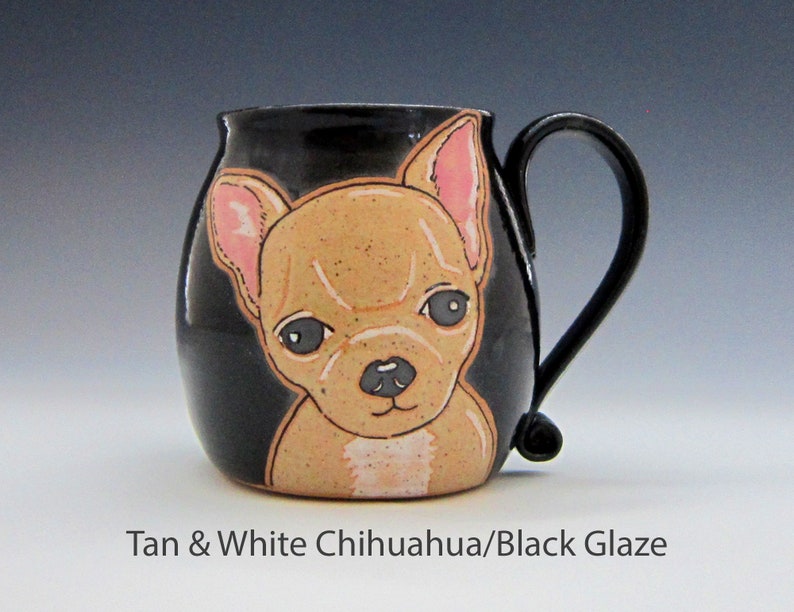 Puede incluir: Una taza de cer&aacute;mica negra con una ilustraci&oacute;n de chihuahua marr&oacute;n y blanco. La taza tiene un esmalte negro y un cuerpo redondeado.
