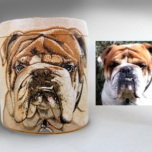 K&ouml;nnte beinhalten: Eine Keramiktasse mit einem handgemalten Bild eines Bulldoggen. Der Bulldogge hat braunes Fell und eine wei&szlig;e Brust. Die Tasse ist hellbraun mit einer gesprenkelten Oberfl&auml;che.