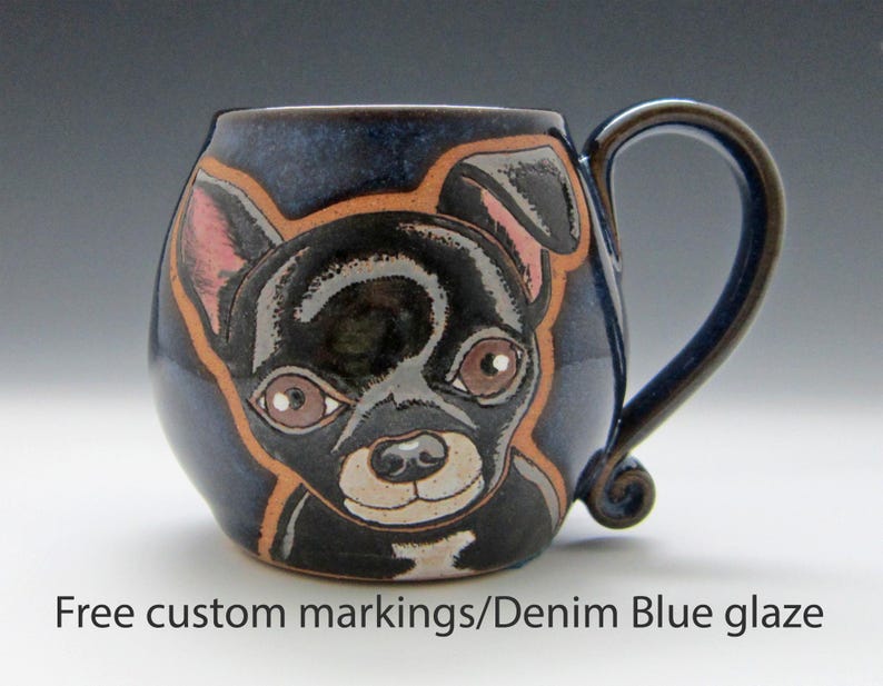 Puede incluir: Una taza de cer&aacute;mica con un dise&ntilde;o pintado a mano de un chihuahua blanco y negro. La taza tiene un esmalte azul denim y un cuerpo redondeado con asa.