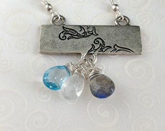 Collar de primera ley con barra floral estampada con piedras preciosas únicas labradorita, piedra lunar y topacio azul. Plata esterlina. Reversible.