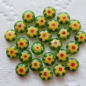 May include: A collection of 20 green glass beads with yellow and red flower designs.