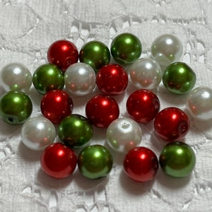 May include: A collection of round, pearl-like beads in red, green, and white.