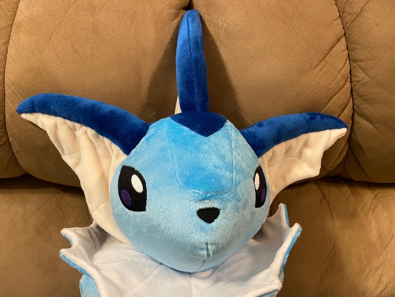 Puede incluir: Un juguete de peluche azul y blanco de un personaje de Pokemon con una aleta en la cabeza y orejas grandes.