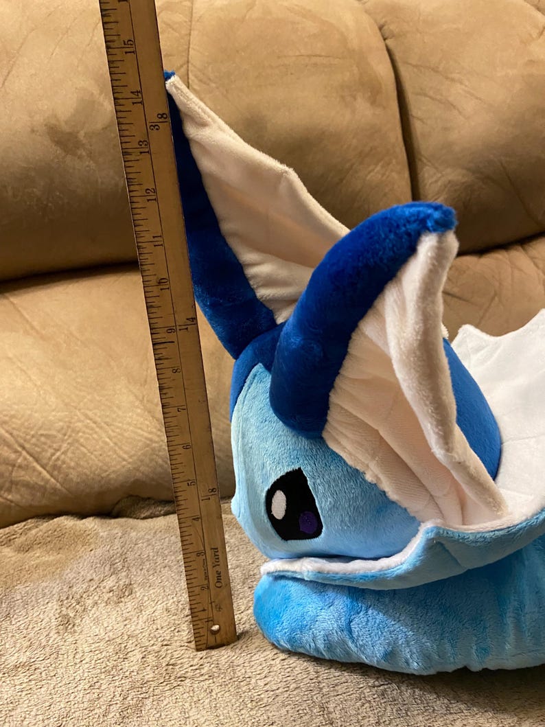 Puede incluir: Un juguete de peluche azul y blanco de un personaje Pok&eacute;mon, Glaceon, con una regla de 38 cm de largo a su lado.