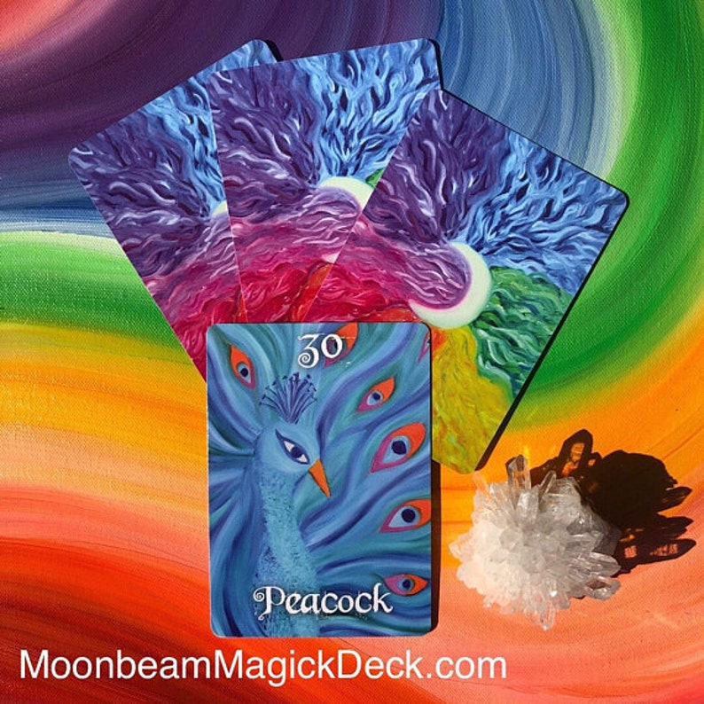 May include: A collection of oracle cards featuring a peacock design, with the word "Peacock" and the number "30" on the front. The cards have a colorful, abstract background with a rainbow gradient. A cluster of clear crystals is also present.