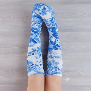 May include: A pair of white knee-high socks with a blue floral pattern.