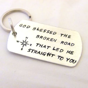 May include: Silver keychain with a compass and the text "God blessed the broken road that led me straight to you".