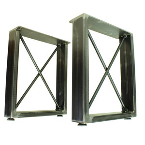 May include: Two black metal table legs with an X-shaped support structure. Each leg has a square base and a rectangular top.