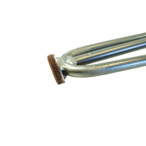 May include: Close-up of a silver heating element with a brown protective covering on the end.