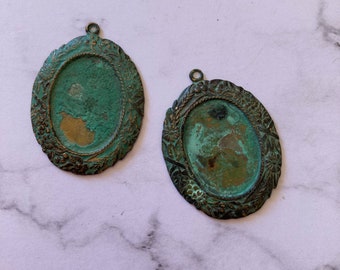 2 pendentifs cadres style victorien pour cabochons 25x18 mm. Ils ont été oxydés pour obtenir une patine vert de gris