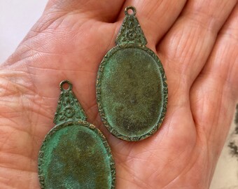 2 pendentifs cadres style victorien pour cabochons. Ils ont été oxydés pour obtenir une patine vert de gris